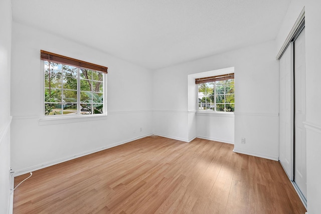 unfurnished bedroom featuring a closet, wood finished floors, and baseboards