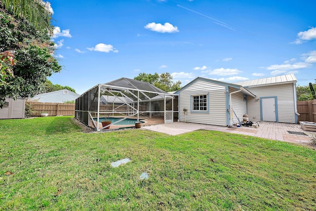 rear view of house with a fenced backyard, a lanai, a yard, a fenced in pool, and a patio area