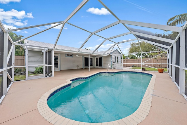 view of swimming pool featuring glass enclosure, a patio area, a fenced backyard, and a fenced in pool