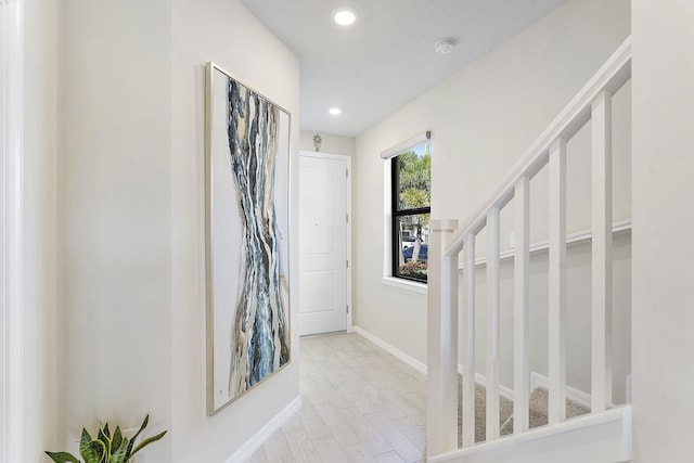 hallway with recessed lighting, baseboards, wood finished floors, and stairs