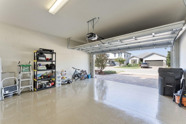 garage with concrete block wall and a garage door opener