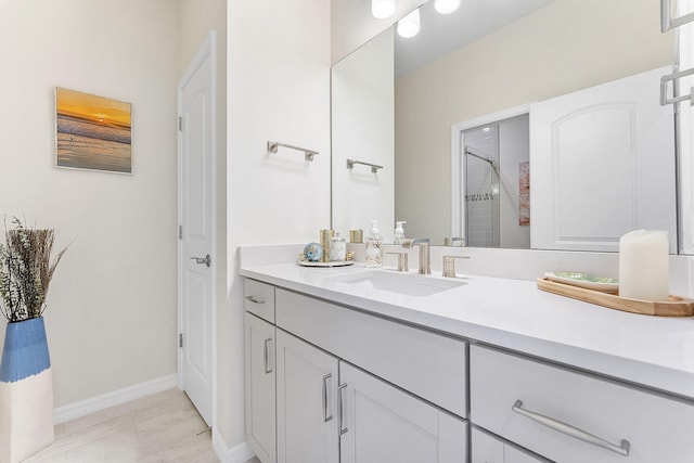 full bathroom featuring vanity, a shower stall, and baseboards