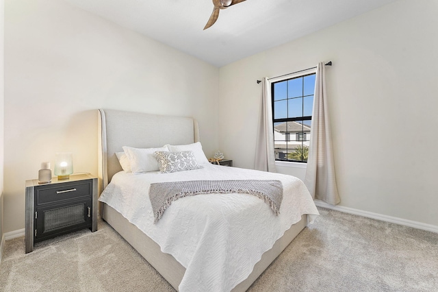 bedroom featuring baseboards, light colored carpet, and a ceiling fan