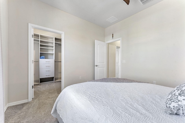 carpeted bedroom with a walk in closet, baseboards, and a closet