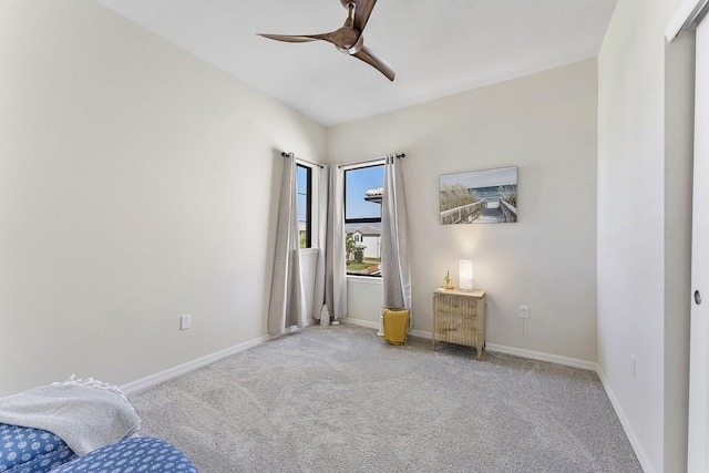 sitting room featuring baseboards, carpet floors, and ceiling fan