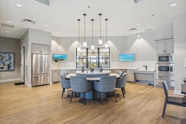 dining room featuring light wood finished floors, visible vents, recessed lighting, and baseboards