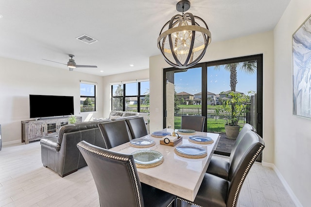 dining space with baseboards, visible vents, light wood finished floors, recessed lighting, and ceiling fan with notable chandelier