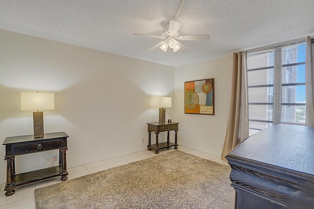 interior space with tile patterned floors, a textured ceiling, and a ceiling fan