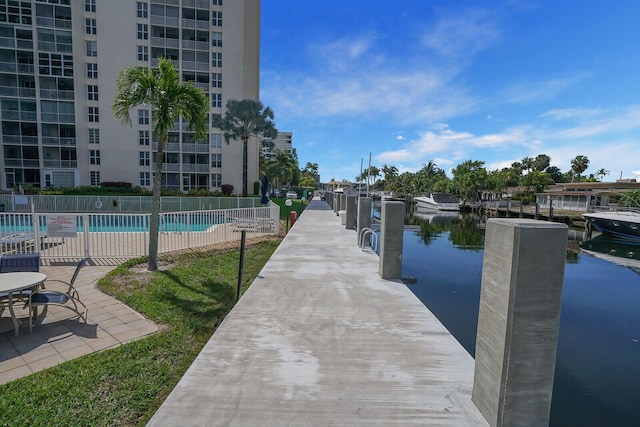 dock area featuring a community pool, a water view, and fence