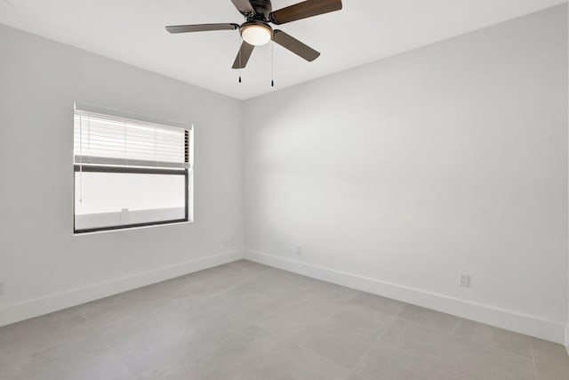 empty room with ceiling fan and baseboards