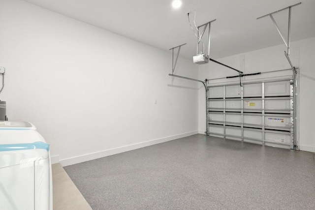 garage featuring a garage door opener, washer and clothes dryer, and baseboards