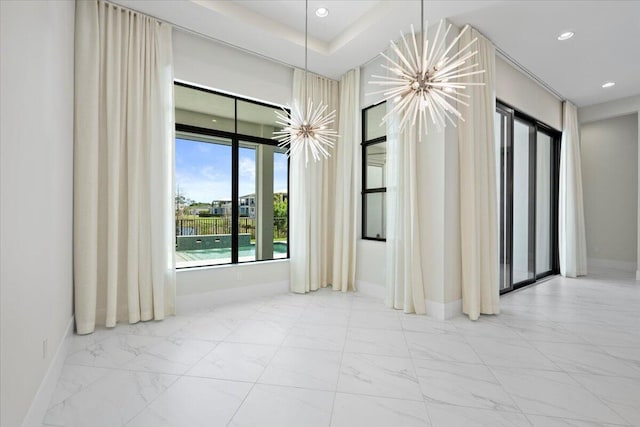 unfurnished room featuring baseboards, marble finish floor, recessed lighting, and a notable chandelier