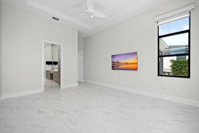 unfurnished room featuring marble finish floor, visible vents, a towering ceiling, ceiling fan, and baseboards