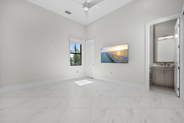 unfurnished bedroom featuring marble finish floor, visible vents, a ceiling fan, ensuite bath, and baseboards