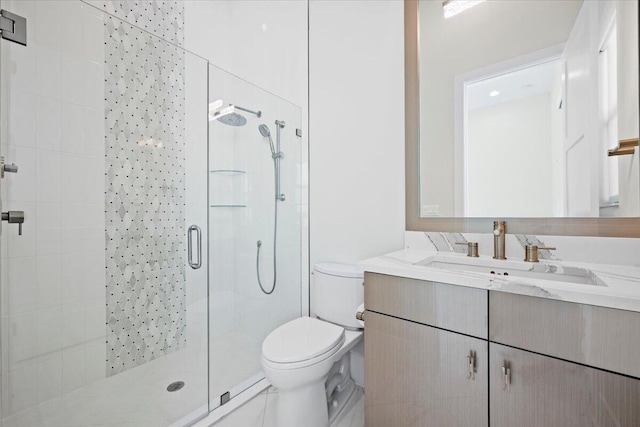 full bathroom featuring a shower stall, toilet, and vanity