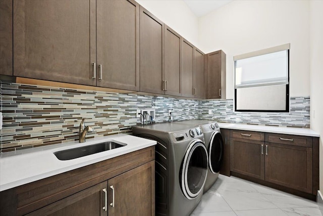 washroom featuring marble finish floor, cabinet space, a sink, and washer and clothes dryer