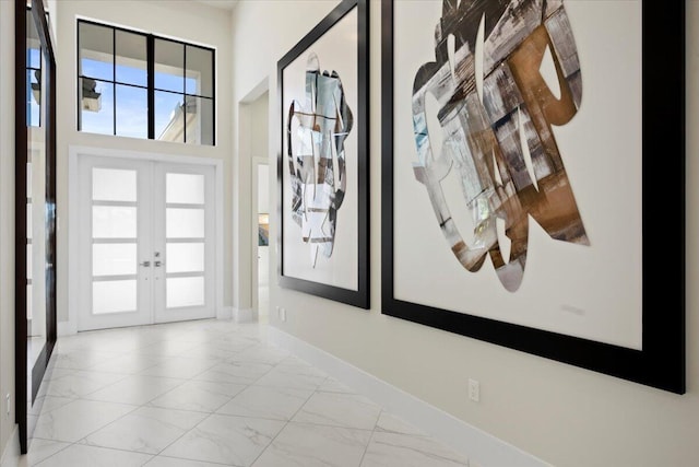 foyer with marble finish floor, french doors, and baseboards