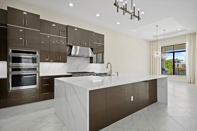 kitchen with modern cabinets, marble finish floor, stainless steel appliances, under cabinet range hood, and a sink