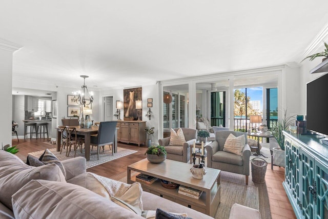 living area with a chandelier, plenty of natural light, wood finished floors, and ornamental molding