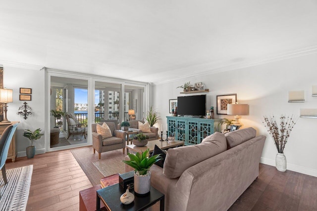 living area featuring baseboards, dark wood-type flooring, and ornamental molding