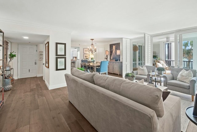 living room featuring crown molding, dark wood-style floors, baseboards, and a chandelier