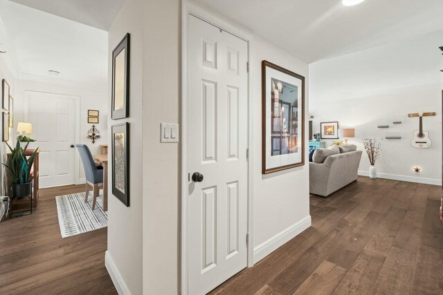 corridor featuring dark wood finished floors and baseboards