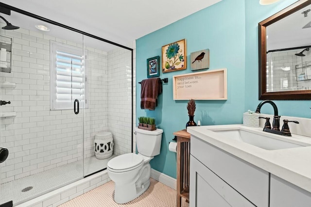 full bath with toilet, a shower stall, tile patterned flooring, baseboards, and vanity