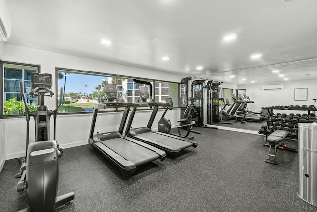 exercise room with recessed lighting, baseboards, and an AC wall unit