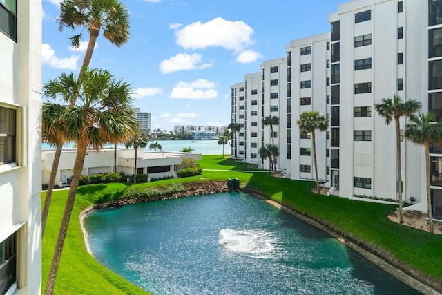 view of swimming pool featuring a yard and a water view