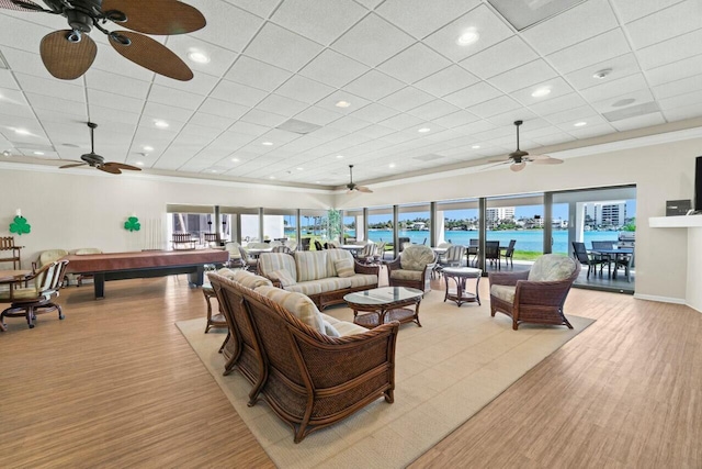 living room featuring light wood-type flooring, crown molding, pool table, a paneled ceiling, and ceiling fan