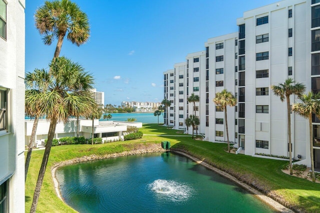 view of pool featuring a lawn and a water view
