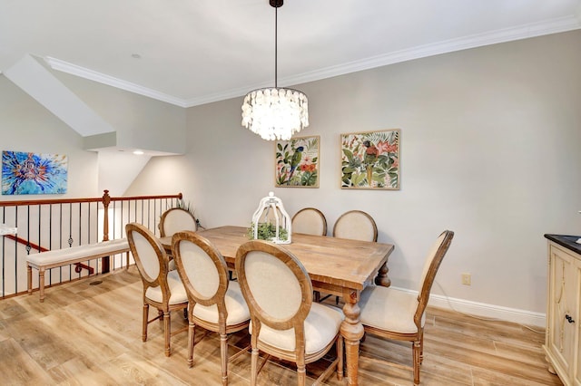 dining room featuring a chandelier, ornamental molding, light wood-style flooring, and baseboards