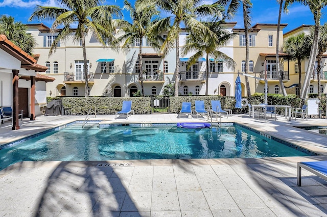 pool featuring a patio, fence, and a residential view