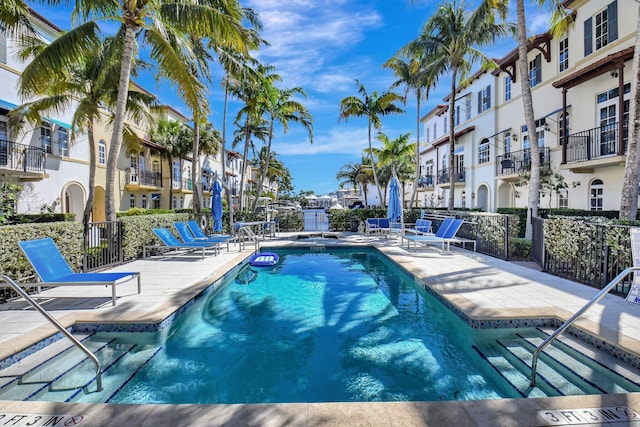 pool with a residential view, a patio, and fence