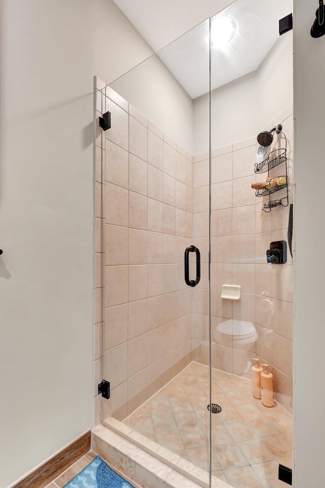 full bath with a stall shower and baseboards