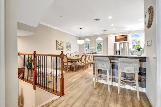 interior space featuring light wood-style flooring, recessed lighting, visible vents, baseboards, and ornamental molding