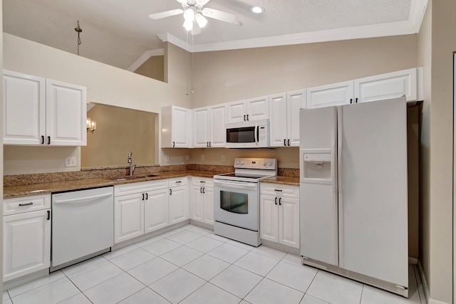 kitchen with a sink, white appliances, ornamental molding, and white cabinetry