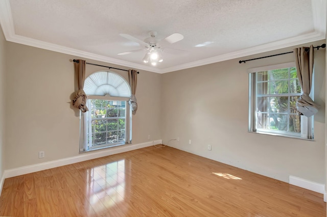 unfurnished room with ornamental molding, baseboards, and wood finished floors