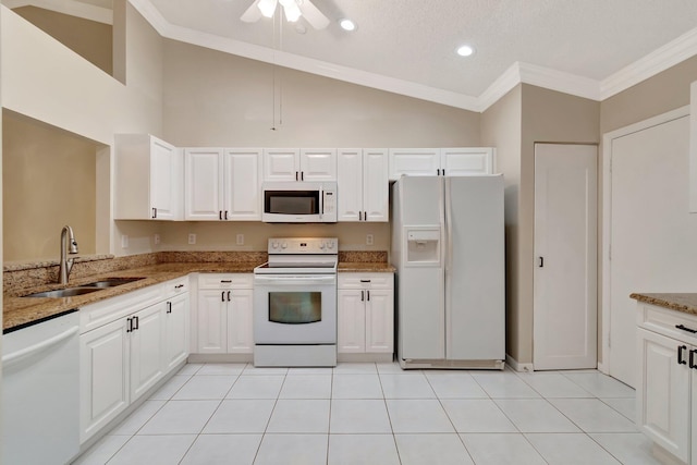 kitchen with a sink, light stone counters, white appliances, crown molding, and light tile patterned floors