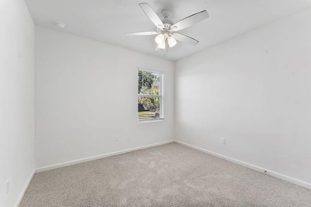 spare room with baseboards, a ceiling fan, and carpet flooring