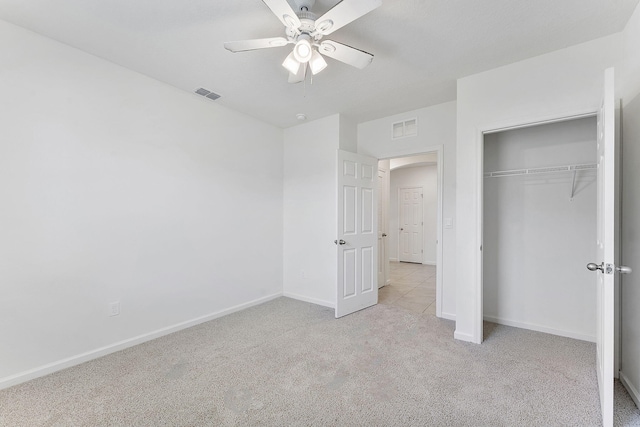 unfurnished bedroom with visible vents, baseboards, light colored carpet, and a closet