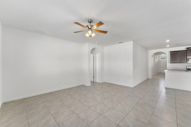 unfurnished room with baseboards, visible vents, recessed lighting, arched walkways, and ceiling fan