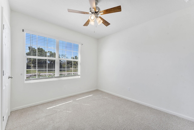 empty room with a ceiling fan, carpet, and baseboards