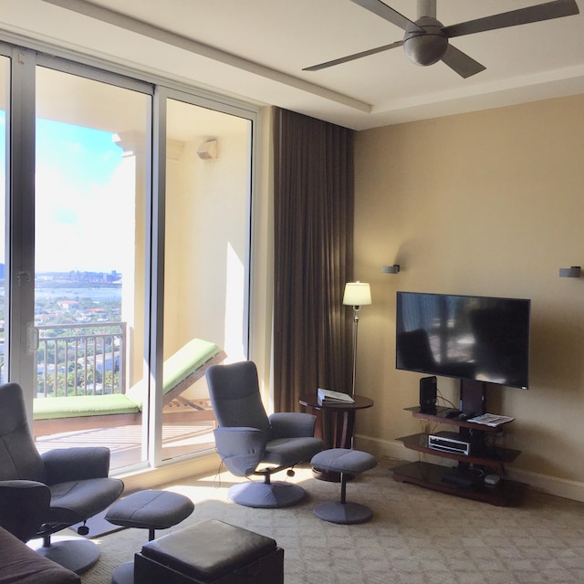 living room with carpet flooring, baseboards, and ceiling fan