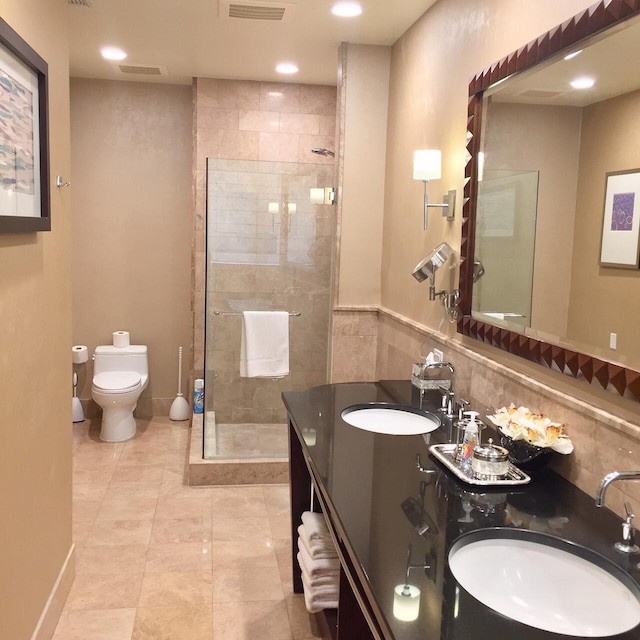 full bath featuring tile walls, toilet, a walk in shower, and a sink