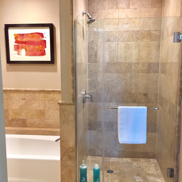 full bathroom featuring a shower stall and a garden tub