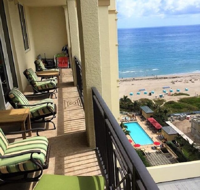 balcony featuring a beach view and a water view