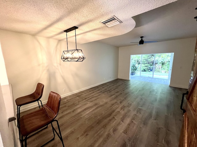 sitting room featuring dark wood-style flooring, visible vents, a textured ceiling, baseboards, and ceiling fan with notable chandelier