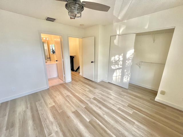 unfurnished bedroom with a closet, visible vents, light wood-style flooring, and baseboards