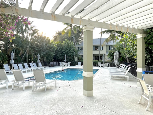 community pool featuring a patio area, fence, and a pergola